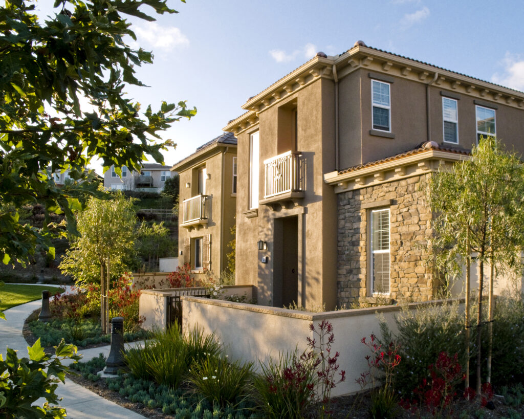 Two-story homes with tiled roofs and landscaped walkways in University Hills